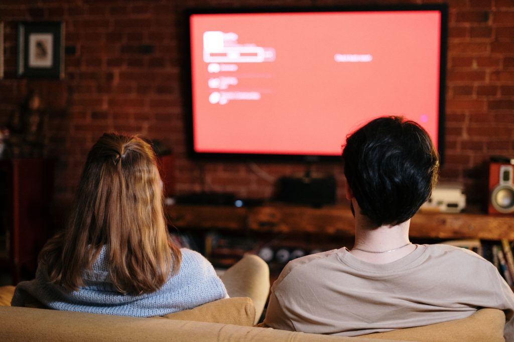 Personen sitzen vor dem Fernseher, 2024 nicht nur, um fern zu sehen