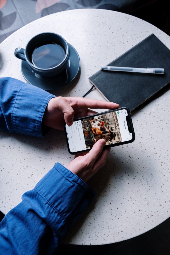 Person hält Smartphone in der Hand, nutzt Instagram