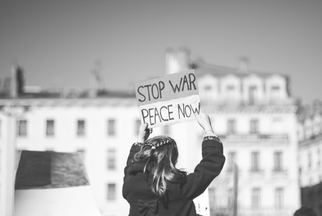 Frau mit "Stop war, peace now" Schild in der Hand